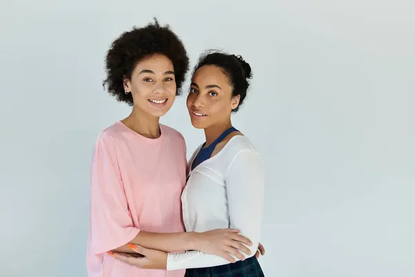 Two friends share a heartfelt moment, radiating joy and warmth in a soft lit space. — Stock Photo