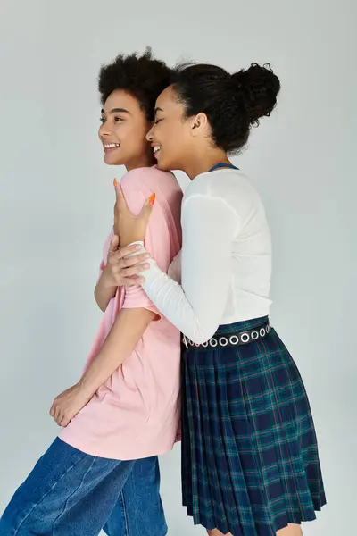 Two friends share a moment of laughter while posing together in a bright studio. — Stock Photo