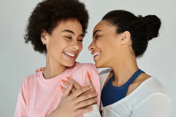 Zwei Frauen umarmen sich freudig, wechseln strahlendes Lächeln und Lachen in gemütlicher Atmosphäre. — Stockfoto