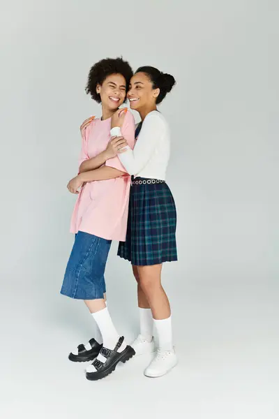 Two friends happily embrace, showcasing their stylish outfits and warm connection. — Stock Photo