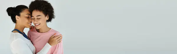 Two women embrace, smiling warmly in a soothing moment of love and togetherness. — Stock Photo