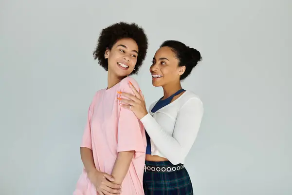 Two friends laugh together, enjoying a playful moment while posing in a modern space. — Stock Photo