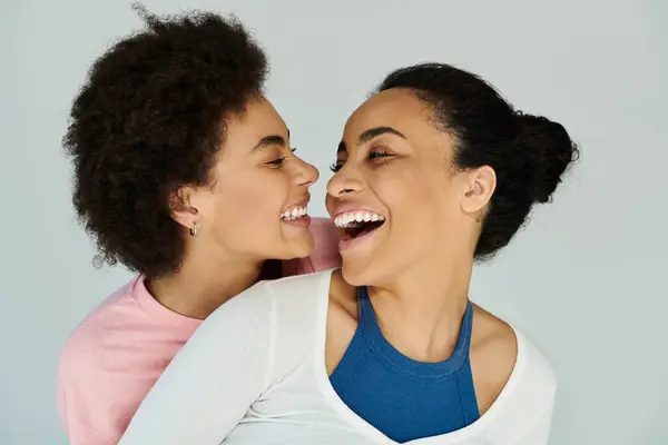 Two friends share a joyful moment, laughing deeply while enjoying each others company indoors. — Stock Photo