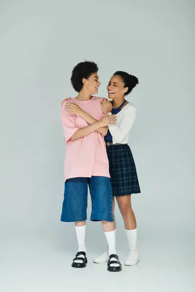 Cheerful interaction between two friends dressed in comfortable clothing, smiling together. — Stock Photo
