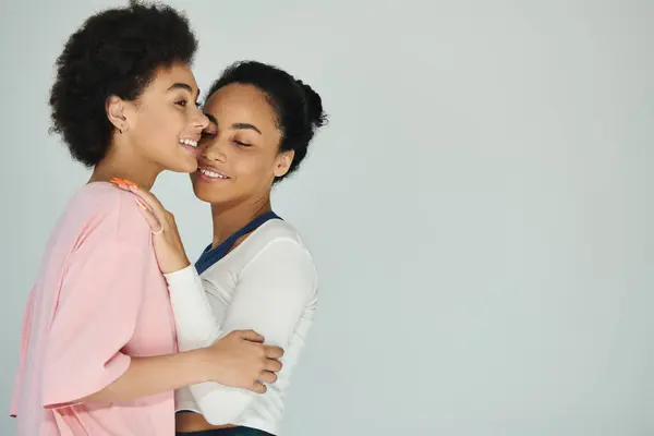 Two women share a tender embrace, reflecting joy and warmth in a peaceful atmosphere. — Stock Photo