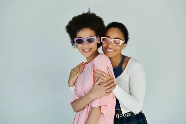 Due amici condividono risate e gioia in un momento accorato su un semplice sfondo. — Foto stock