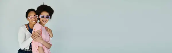 Two women share a joyful moment, embracing and showcasing their playful style in bright attire. — Stock Photo