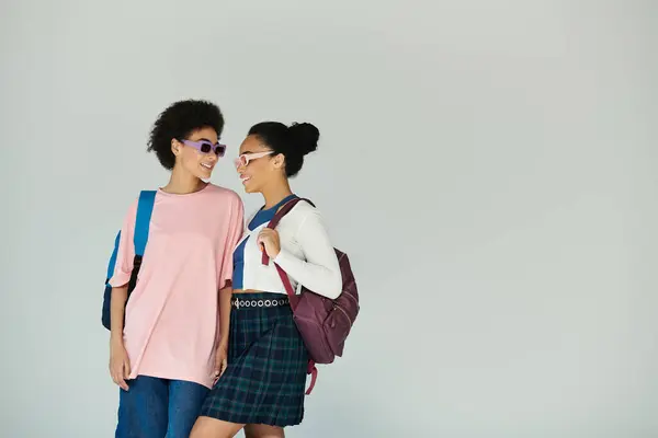 Deux amis profitent d'un moment de joie ensemble, mettant en valeur leurs tenues à la mode et leur esprit ludique. — Photo de stock