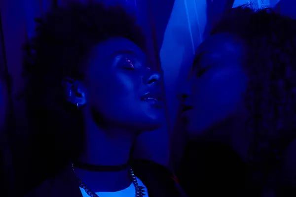 Deux figures partagent un lien étroit, enveloppé d'une lumière bleue frappante, exprimant l'émotion. — Photo de stock