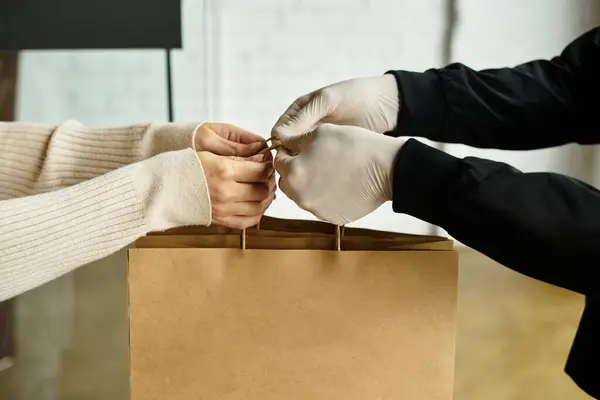 Ein Zusteller übergibt ein Paket sorgfältig an einen Kunden in einem modernen Büroumfeld. — Stockfoto