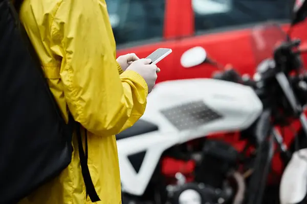 A delivery man brings an order to an office building, using smartphone, showcasing modern service. — Stock Photo