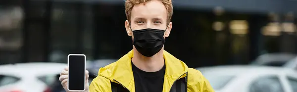 A delivery man in a black medical mask is arriving at an office building — Stock Photo