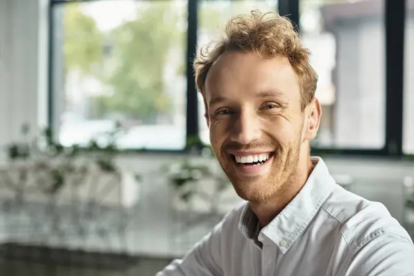 Un hombre de negocios comprometido con el pelo rojo está trabajando diligentemente en un proyecto en un entorno de oficina contemporáneo. — Stock Photo