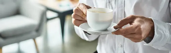 A diligent businessman dressed in a white shirt enjoys coffee while working on innovative project ideas. — Stock Photo