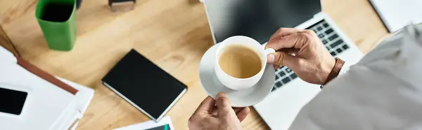 A redhead businessman in a white shirt engages deeply in his project work while sipping coffee. — Stock Photo