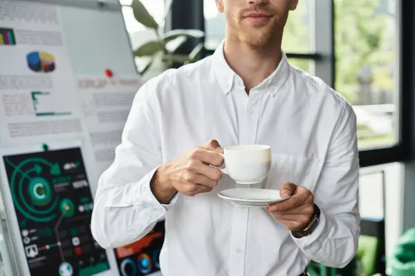 A focused redhead businessman sips coffee, deep in thought about a project in his stylish office. — Stock Photo