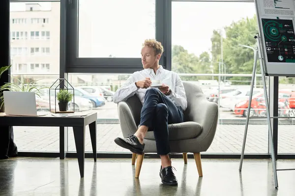 A determined redhead in a white shirt analyzes his project notes in a modern office environment. — Stock Photo
