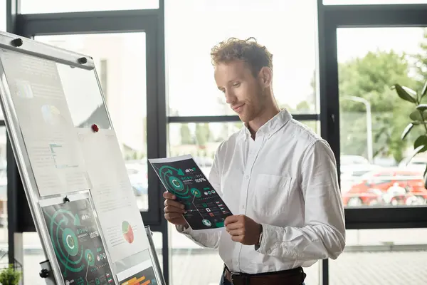 The redhead businessman in a white shirt studies project documents in a stylish, contemporary office environment. — Stock Photo