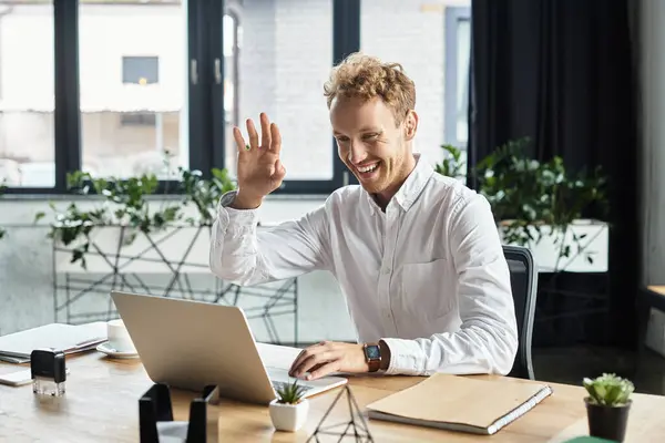 Um empresário ruivo em uma camisa branca se envolve alegremente em um projeto de trabalho enquanto sentado em uma mesa elegante. — Fotografia de Stock