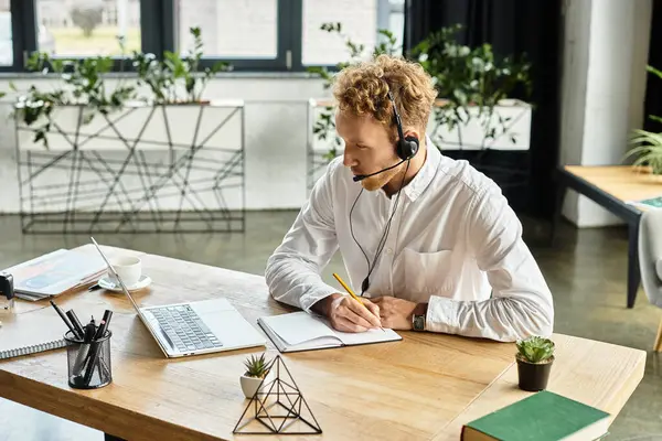 In a contemporary office, a redheaded businessman in a white shirt diligently works on his project, taking notes. — Stock Photo