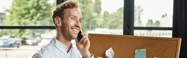 Ein fokussierter Geschäftsmann mit roten Haaren diskutiert aktiv sein Projekt, während er in einem eleganten Büro steht. — Stockfoto