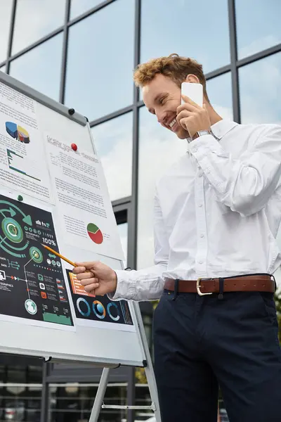 A redhead businessman in a white shirt engages in a project discussion while standing in an office. — Stock Photo