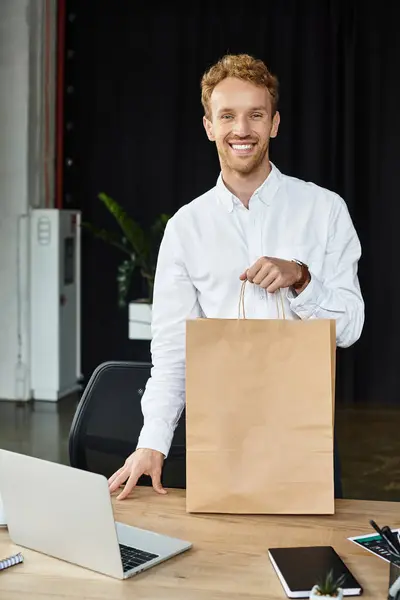 A redhead man in a white shirt smiles while engaging with a project in a stylish office environment. — Stock Photo