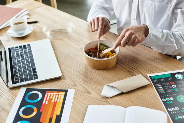 A focused professional indulges in lunch while multitasking on a project in a stylish office. — Stock Photo