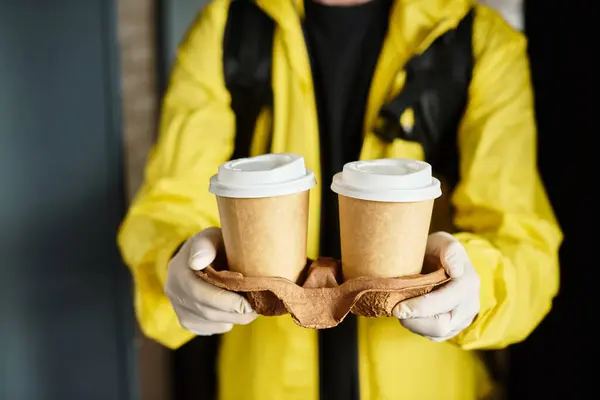 A delivery man carries freshly brewed coffee orders into a busy office. — Stock Photo