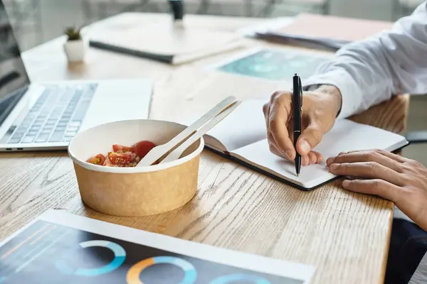 Businessman in a white shirt diligently works on his project while enjoying lunch at the desk. — Stock Photo