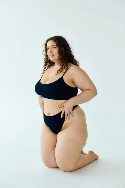 Une belle femme de taille plus met en valeur sa confiance avec une pose prête dans un cadre minimaliste. — Photo de stock