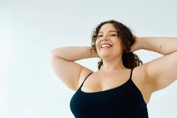 A vibrant plus size woman with curly hair radiates happiness, embracing her confident spirit. — Stock Photo