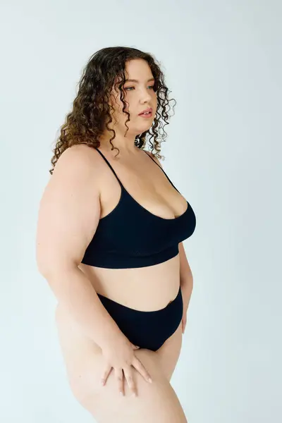 A confident plus size woman models chic black lingerie, radiating beauty and self love. — Stock Photo
