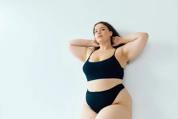 A stunning plus size woman exudes confidence while striking a pose, showcasing her beauty. — Stock Photo
