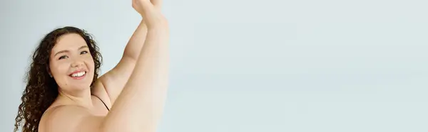 A radiant plus size woman exudes joy as she raises her arms, reveling in the moment. — Stock Photo