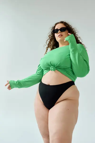 Una impresionante mujer de talla grande posa con gracia, celebrando la positividad corporal y la moda. - foto de stock