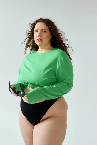 A beautiful plus size woman showcases her style in a vibrant outfit, exuding confidence. — Stock Photo