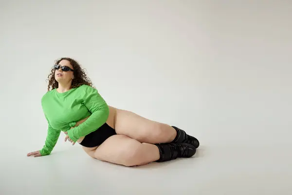 Una mujer confiada de talla grande exhibe su estilo único en un atuendo verde audaz y accesorios elegantes. — Stock Photo