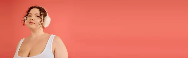 The plus size woman poses elegantly, showcasing her confidence in soft colors and accessories. — Stock Photo