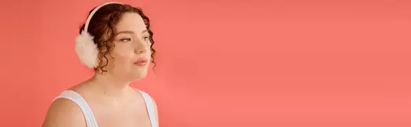 A stunning plus size woman showcases her beauty, wearing soft ear muffs and embracing her style. — Stock Photo