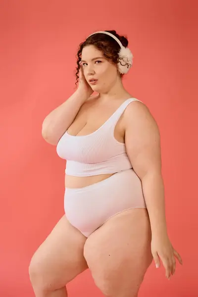 A beautiful plus size woman stands elegantly, showcasing her confidence in a playful pose. — Stock Photo