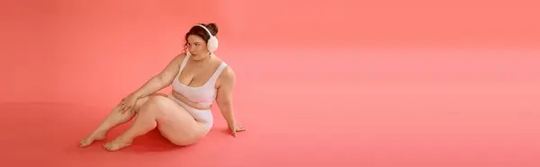 Eine Plus-Size-Frau präsentiert mühelos Selbstvertrauen und Stil in einer schicken, pastellfarbenen Umgebung. — Stock Photo