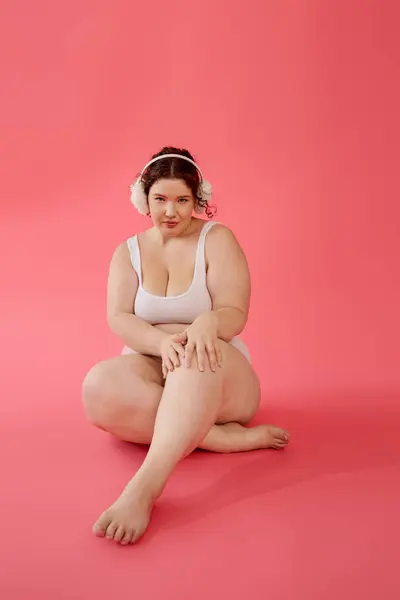 A mulher plus size, sentada graciosamente, mostra confiança e beleza em um ambiente brilhante. — Fotografia de Stock