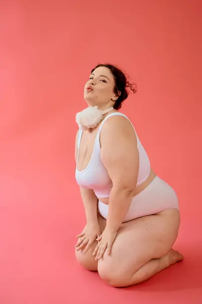 A plus size woman with a radiant smile poses playfully on her knees, exuding confidence. — Stock Photo