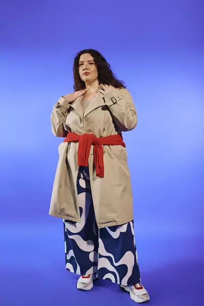 A confident plus size woman poses in a trendy outfit against a bold background. — Stock Photo
