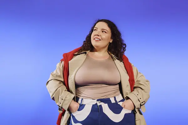 A plus size woman showcases her confidence while posing in a chic outfit, radiating joy. — Stock Photo