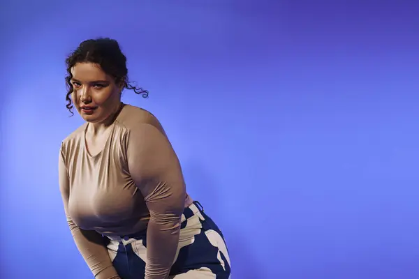 Una mujer de talla grande mostrando su estilo único contra un fondo azul vivo, irradiando confianza. — Stock Photo