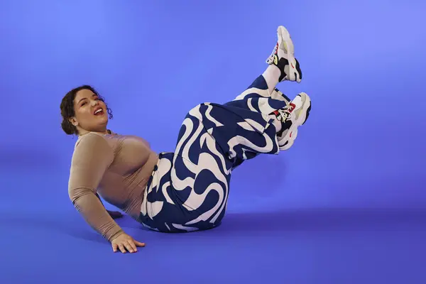 Женщина plus size радостно отступает, демонстрируя свою жизнерадостную личность в живом наряде. — стоковое фото