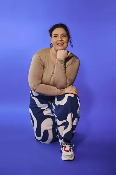 Esta mulher confiante plus size exala beleza enquanto se ajoelha em traje estampado impressionante. — Fotografia de Stock