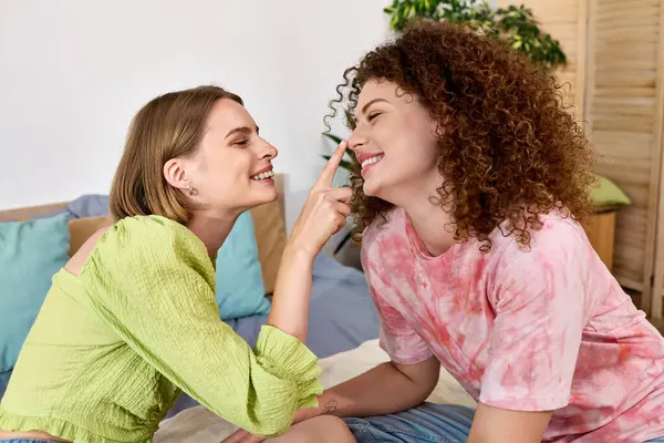 A delighted young couple shares laughter and playful touches in their intimate space together. — Stock Photo
